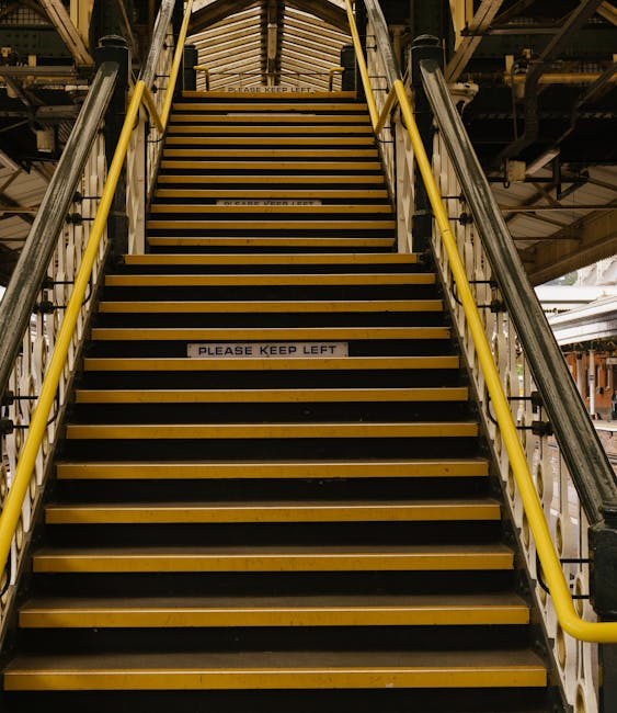 Inside Barking station at sunset, the image shows a spacious entrance area with multiple ticket barriers, including a security gate marked with a wheelchair accessibility symbol on the left. Several t